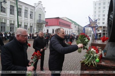 Жители Могилева несут цветы к памятному знаку «Рукопожатие» в память о погибших в теракте в Подмосковье
